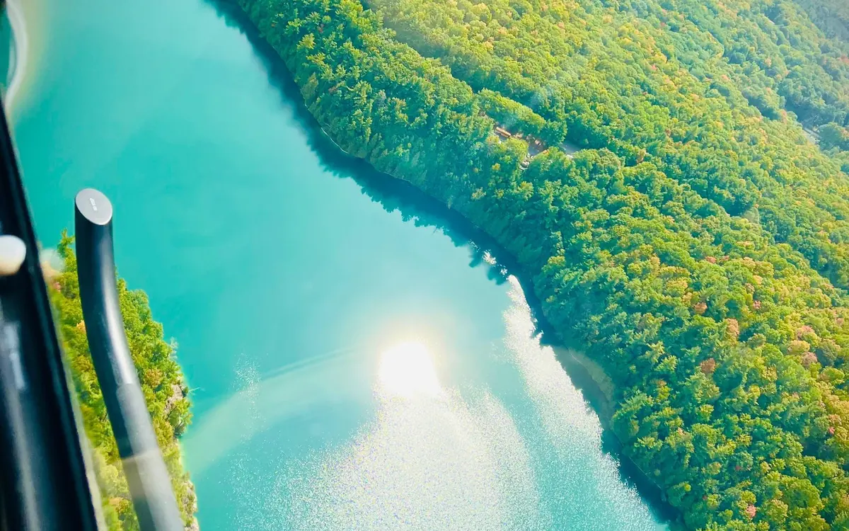 A helicopter above the forest and lakes of Gatineau Park