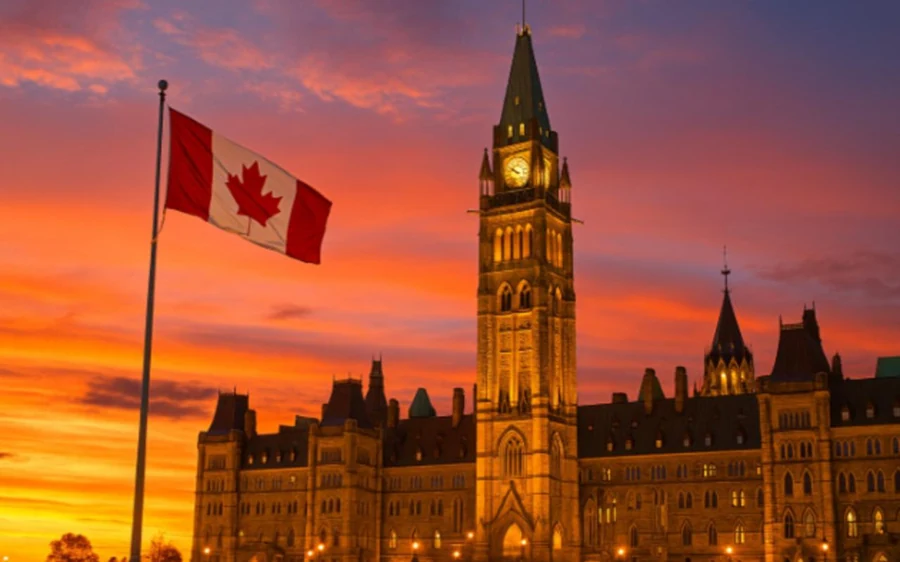Der Peace Tower und die kanadische Flagge auf Parliament Hill bei Sonnenuntergang